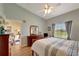 Cozy bedroom with ceiling fan, large window, view to living room and neutral color scheme at 1235 Saxony Cir # 5202, Punta Gorda, FL 33983