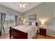 Comfortable bedroom featuring a large window with blinds, wooden floors, a ceiling fan and a queen bed at 1235 Saxony Cir # 5202, Punta Gorda, FL 33983