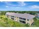 Aerial view of the condo complex featuring a long building with screened lanais and green lawns at 1235 Saxony Cir # 5202, Punta Gorda, FL 33983