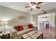 Inviting living room featuring a tan sofa, decorative pillows and an open view of the modern, all-white kitchen at 1235 Saxony Cir # 5202, Punta Gorda, FL 33983
