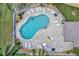 Aerial view showcases a freeform pool with surrounding patio, lounge chairs, and lush greenery at 1235 Saxony Cir # 5202, Punta Gorda, FL 33983