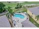 Aerial shot of a private kidney-shaped pool with sun loungers and palm trees in a fenced-in patio area at 1235 Saxony Cir # 5202, Punta Gorda, FL 33983