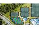 An aerial view showcasing tennis and pickleball courts, surrounded by lush greenery, at this property at 14617 Sycamore Ct # 2211, Punta Gorda, FL 33955