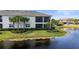 Exterior home view with lake, professional landscaping, and screened-in patio at 14617 Sycamore Ct # 2211, Punta Gorda, FL 33955