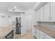 Modern kitchen featuring stainless steel appliances, granite countertops, white cabinets, and a large pantry at 14617 Sycamore Ct # 2211, Punta Gorda, FL 33955