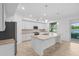 Well-lit kitchen featuring stainless appliances, a spacious island, and a view of the lanai at 14617 Sycamore Ct # 2211, Punta Gorda, FL 33955