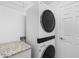 Laundry room featuring stacked washer and dryer and granite countertops at 14617 Sycamore Ct # 2211, Punta Gorda, FL 33955