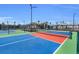 Close-up of a vibrant blue and red pickleball court with black fencing surrounding it in Heritage Landing at 14617 Sycamore Ct # 2211, Punta Gorda, FL 33955