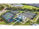 An aerial view of the tennis and pickleball courts next to a lake and golf course at 14617 Sycamore Ct # 2211, Punta Gorda, FL 33955