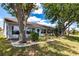 Backyard view of single story home with mature trees and lush landscaping and a white exterior at 1872 Birmingham Blvd, Port Charlotte, FL 33980