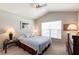 A comfortable bedroom features soft carpet, a ceiling fan, and a large window with natural light at 1872 Birmingham Blvd, Port Charlotte, FL 33980
