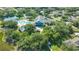 Scenic aerial view of the community clubhouse, pool, tennis courts, and surrounding greenery at 19325 Water Oak Dr # 305, Port Charlotte, FL 33948