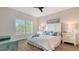 Bright bedroom with a ceiling fan, white furnishings, light blue accents, and ample natural light at 19325 Water Oak Dr # 305, Port Charlotte, FL 33948