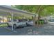 Carport parking area with parking spaces, shading, and some vegetation at 19325 Water Oak Dr # 305, Port Charlotte, FL 33948