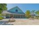 Clubhouse exterior featuring stone patio set with a building with a gray metal roof at 19325 Water Oak Dr # 305, Port Charlotte, FL 33948