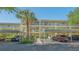 Exterior shot of condo building showing parking and entrance with attractive landscaping at 19325 Water Oak Dr # 305, Port Charlotte, FL 33948