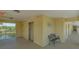 Hallway featuring an elevator, a bench, an exit, and palm trees in the distance at 19325 Water Oak Dr # 305, Port Charlotte, FL 33948