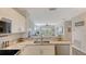 Modern kitchen view into the living area, featuring stainless steel appliances and stone countertops at 19325 Water Oak Dr # 305, Port Charlotte, FL 33948