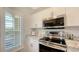 Modern kitchen includes stainless steel appliances, white cabinets, and ample natural light at 19325 Water Oak Dr # 305, Port Charlotte, FL 33948
