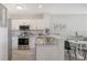 Bright kitchen features stainless steel appliances, white cabinets, granite countertops, and a breakfast bar at 19325 Water Oak Dr # 305, Port Charlotte, FL 33948