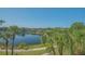 Scenic lake view featuring lush greenery and clear blue water, seen from a residential window at 19325 Water Oak Dr # 305, Port Charlotte, FL 33948