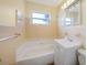 Bathroom featuring a window, tub, vanity, and tile walls at 22220 Lasalle Rd, Port Charlotte, FL 33952