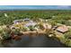 Aerial view of a charming green home with a backyard waterfront view and mature landscaping at 2244 Meetze St, Port Charlotte, FL 33953