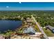 Aerial view of the property with the property lines, lake frontage, landscaping, and pool at 2244 Meetze St, Port Charlotte, FL 33953