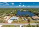 Aerial view showcasing the property, its lush landscaping, and beautiful lake frontage with property lines at 2244 Meetze St, Port Charlotte, FL 33953