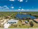 Expansive aerial view showcasing the beautiful property, lake, and surrounding lush greenery at 2244 Meetze St, Port Charlotte, FL 33953