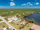 Aerial view showcasing the property, its lush landscaping, and beautiful lake frontage with property lines at 2244 Meetze St, Port Charlotte, FL 33953