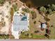 Aerial view of a green home with a screened lanai and mature landscaping along the waterfront at 2244 Meetze St, Port Charlotte, FL 33953