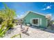 Backyard exterior of a green home with a private screened-in lanai and quaint bistro table at 2244 Meetze St, Port Charlotte, FL 33953