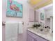 Charming bathroom with colorful flamingo art, lilac vanity, ample counter space, and stylish decor at 2244 Meetze St, Port Charlotte, FL 33953