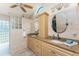 Well-lit bathroom boasts double vanities, storage, granite countertops, and tiled glass block shower at 2244 Meetze St, Port Charlotte, FL 33953