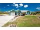 Charming single-story home with lush lawn, vibrant landscaping, and attached two-car garage at 2244 Meetze St, Port Charlotte, FL 33953