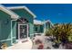 Inviting green home with a screened front door, decorative windows, and professionally landscaped front yard at 2244 Meetze St, Port Charlotte, FL 33953