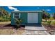 Exterior of a garden shed with gray double doors, a window, and a small, covered deck at 2244 Meetze St, Port Charlotte, FL 33953