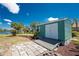 Exterior of a green garden shed with double doors, a window, and a small deck overlooking the yard at 2244 Meetze St, Port Charlotte, FL 33953
