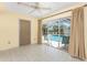 Enclosed sunroom featuring tile floor, fan, and sliding glass doors showcasing the pool area at 2244 Meetze St, Port Charlotte, FL 33953