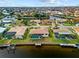 Aerial shot features a waterfront property with a private dock and enclosed pool, surrounded by lush landscaping at 2310 El Cerito Ct, Punta Gorda, FL 33950