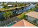 Aerial view showing the backyard with a screened-in pool, canal access and boat lift at 2310 El Cerito Ct, Punta Gorda, FL 33950