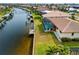 An aerial image of a waterfront house and dock, with a pool in a screened enclosure, with lawn leading to the canal at 2310 El Cerito Ct, Punta Gorda, FL 33950