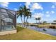 Picturesque backyard with a screened-in pool, lush lawn, canal and direct waterfront access at 2310 El Cerito Ct, Punta Gorda, FL 33950