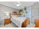 Comfortable bedroom with a palm tree mural, ceiling fan, and wooden furniture at 2310 El Cerito Ct, Punta Gorda, FL 33950