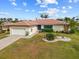 Charming single-story home with a well-manicured front yard, a garage and a blue front door at 2310 El Cerito Ct, Punta Gorda, FL 33950