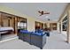 A covered outdoor patio features sleek outdoor furniture, ceiling fans, and views of the bedroom through sliding glass doors at 2310 El Cerito Ct, Punta Gorda, FL 33950