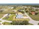 Aerial view of house amongst other homes and canals in a community with lush green lawns at 24294 Santa Inez Rd, Punta Gorda, FL 33955