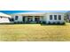 Expansive backyard with lush green lawn extending from a home with a metal roof and covered patio at 24294 Santa Inez Rd, Punta Gorda, FL 33955