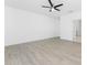 A spacious room with hardwood-style floors, a ceiling fan, and neutral white walls at 24294 Santa Inez Rd, Punta Gorda, FL 33955